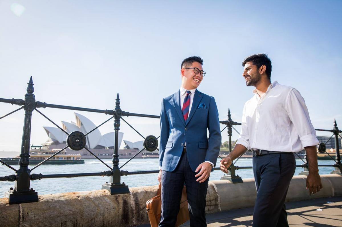 Two UNSW Law students walk past the Sydney Opera House