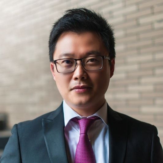 Associate Professor Weihuan Zhou, wearing a purple tie and dark suit