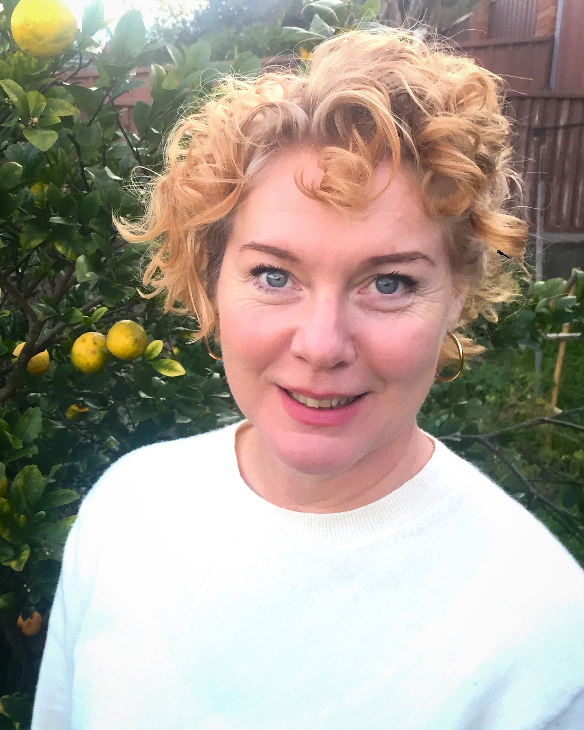 A picture of Associate Professor Erin Brannigan in front of a lemon tree. 