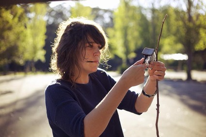 Clare Britton holding a camera in nature