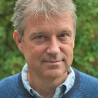 Man with grey hair and blue jumper