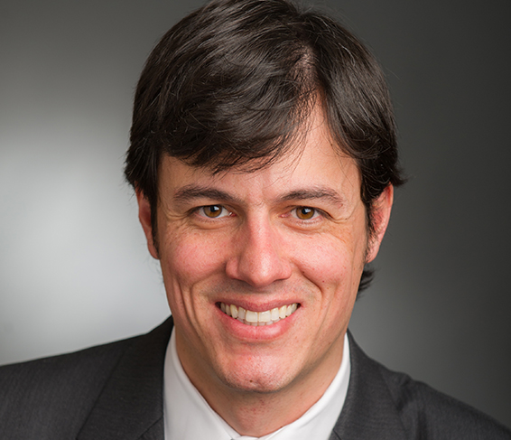 Photograph of a professional man with dark hair smiling