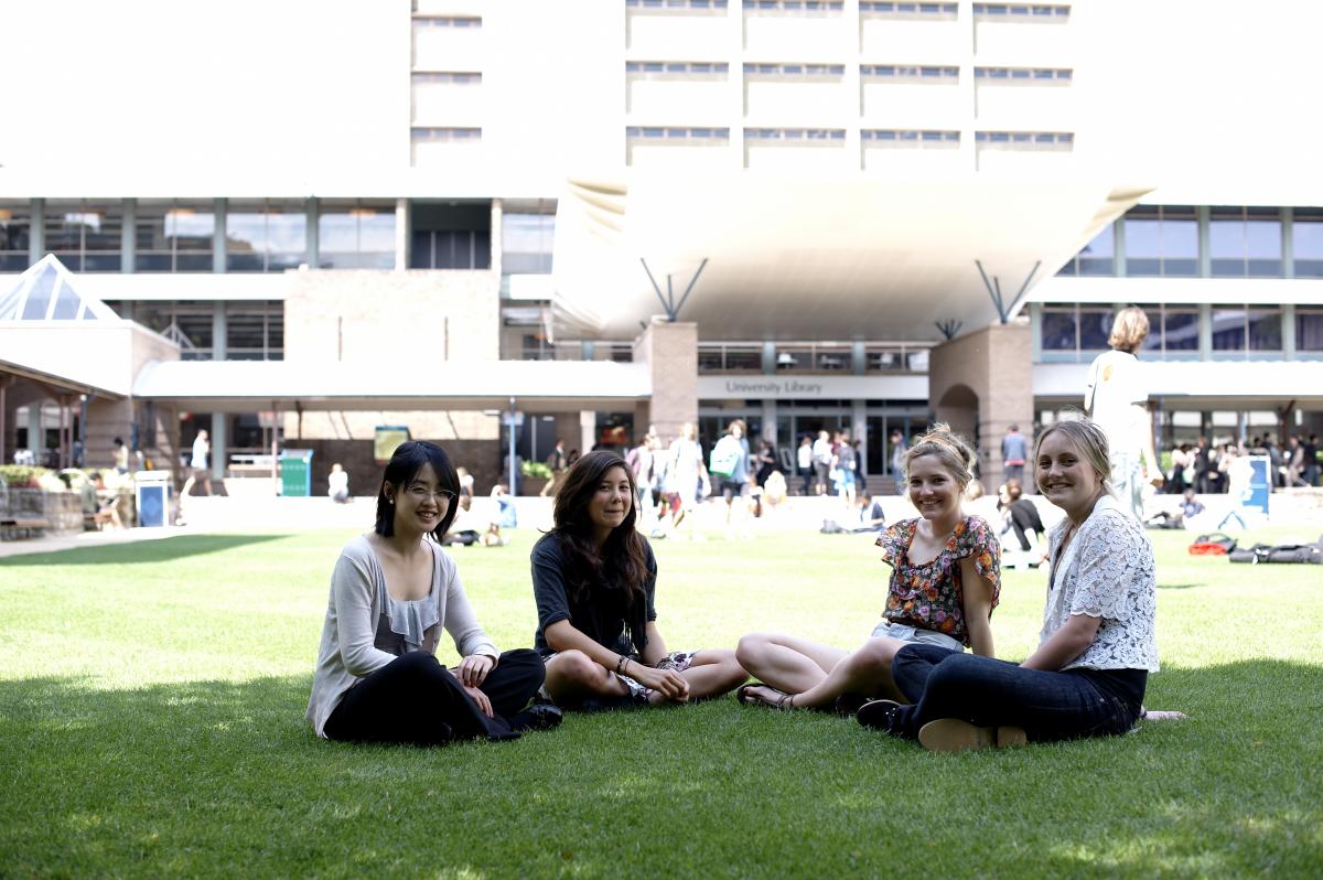 Girls sitting on the library lawn at UNSW