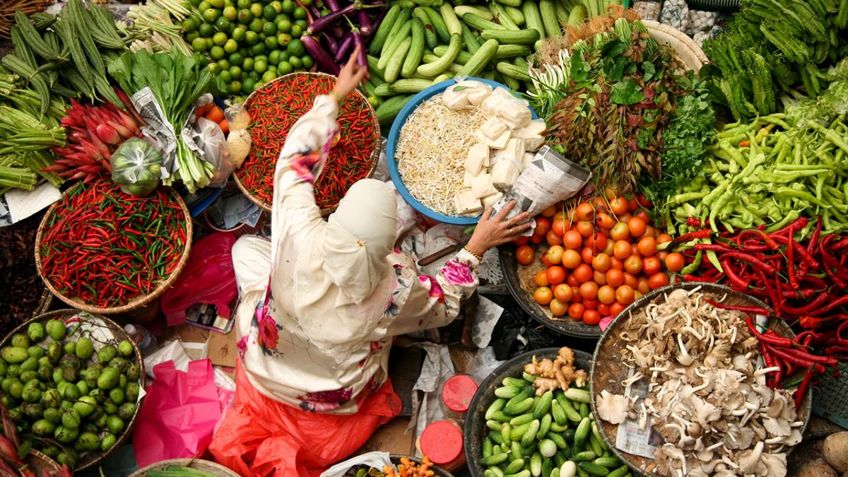 Woman amongst baskets of colourful food