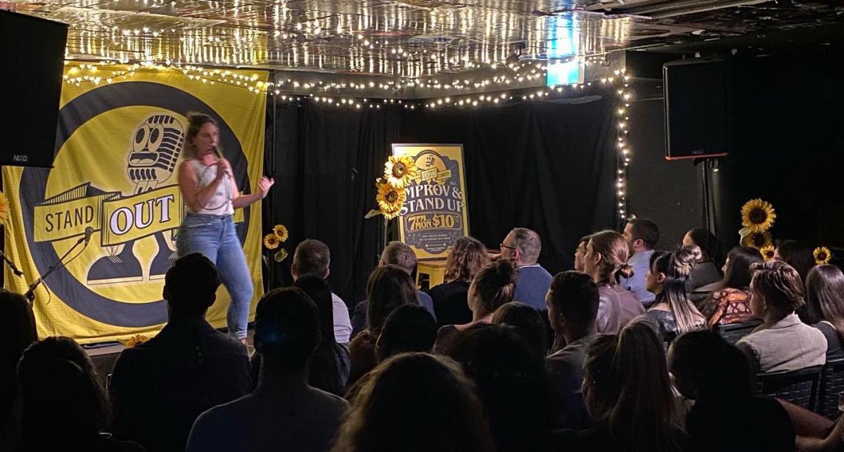 female comedian doing stand up show to live audience