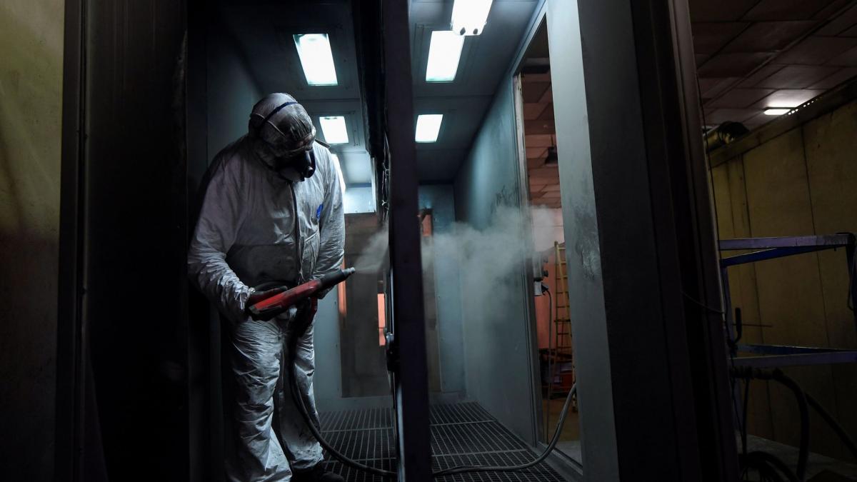 photo of a person in a hazmat suit spraying inside