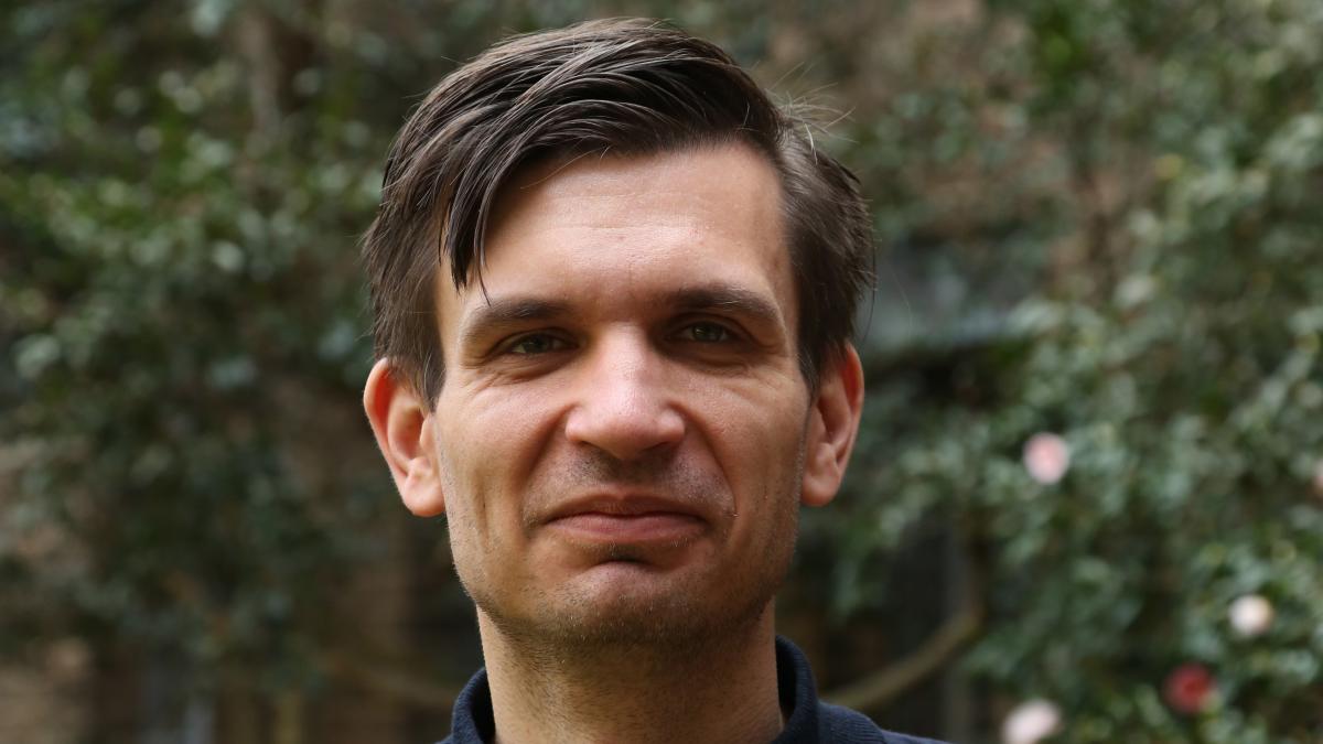 Headshot of a man against trees