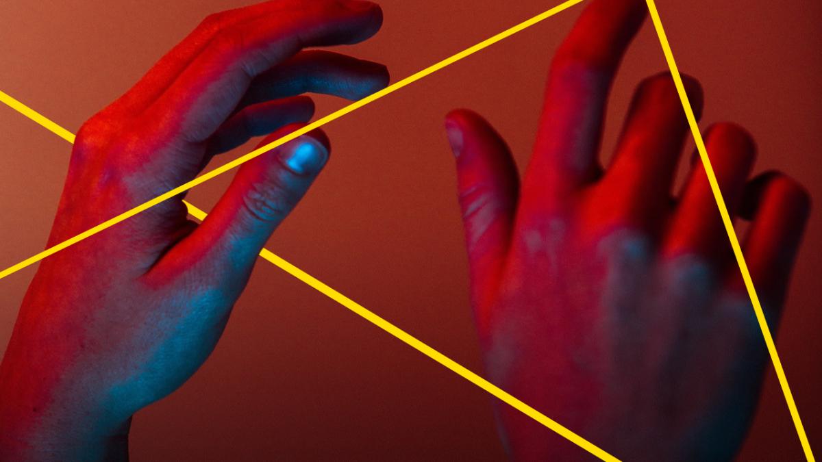 Close up image of hands with bright lines layered over and under them. 