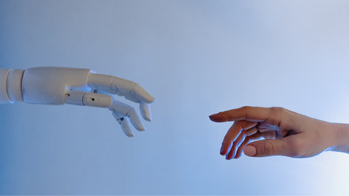 a robotic hand and a human hand reaching towards one another