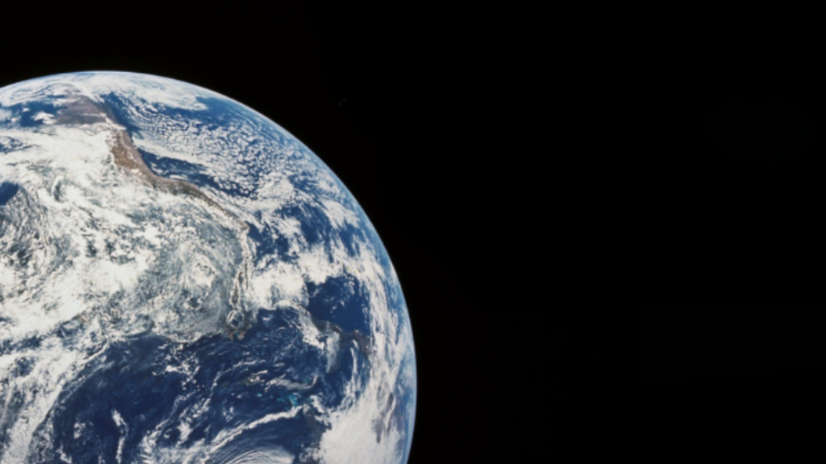 View of Earth from space showing North and Central America with swirling clouds over the blue ocean, set against the blackness of space