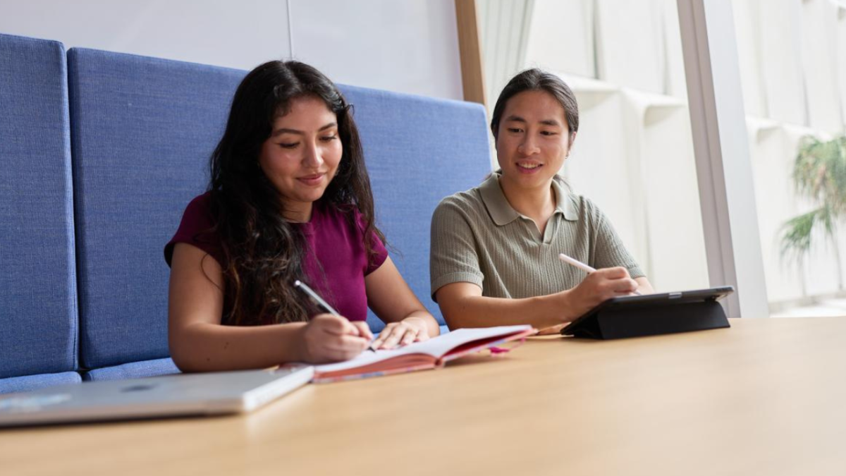 Two UNSW students sit at a table in a study space